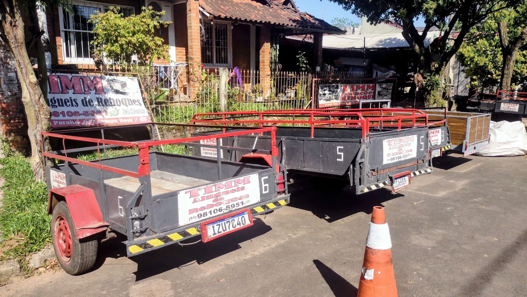 Carretinhas nº 5 e 6 da Timm estacionadas na calçada, com cone na frente